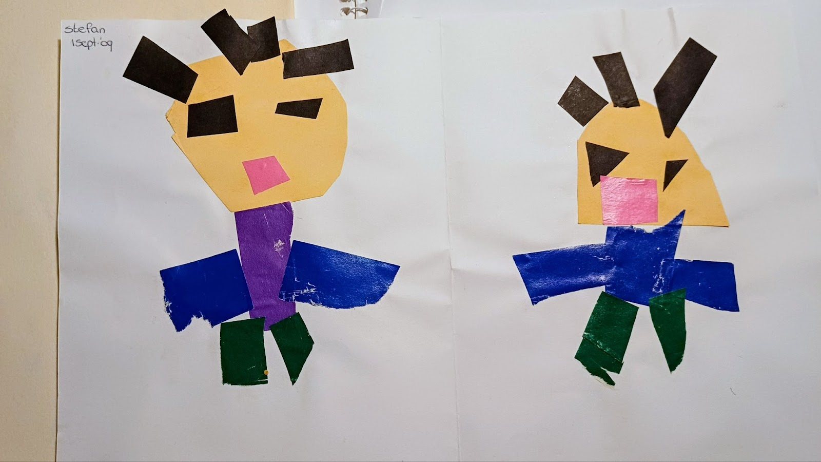 Twee geknutselde figuren van papier in verschillende kleuren, gemaakt als schoolopdracht.